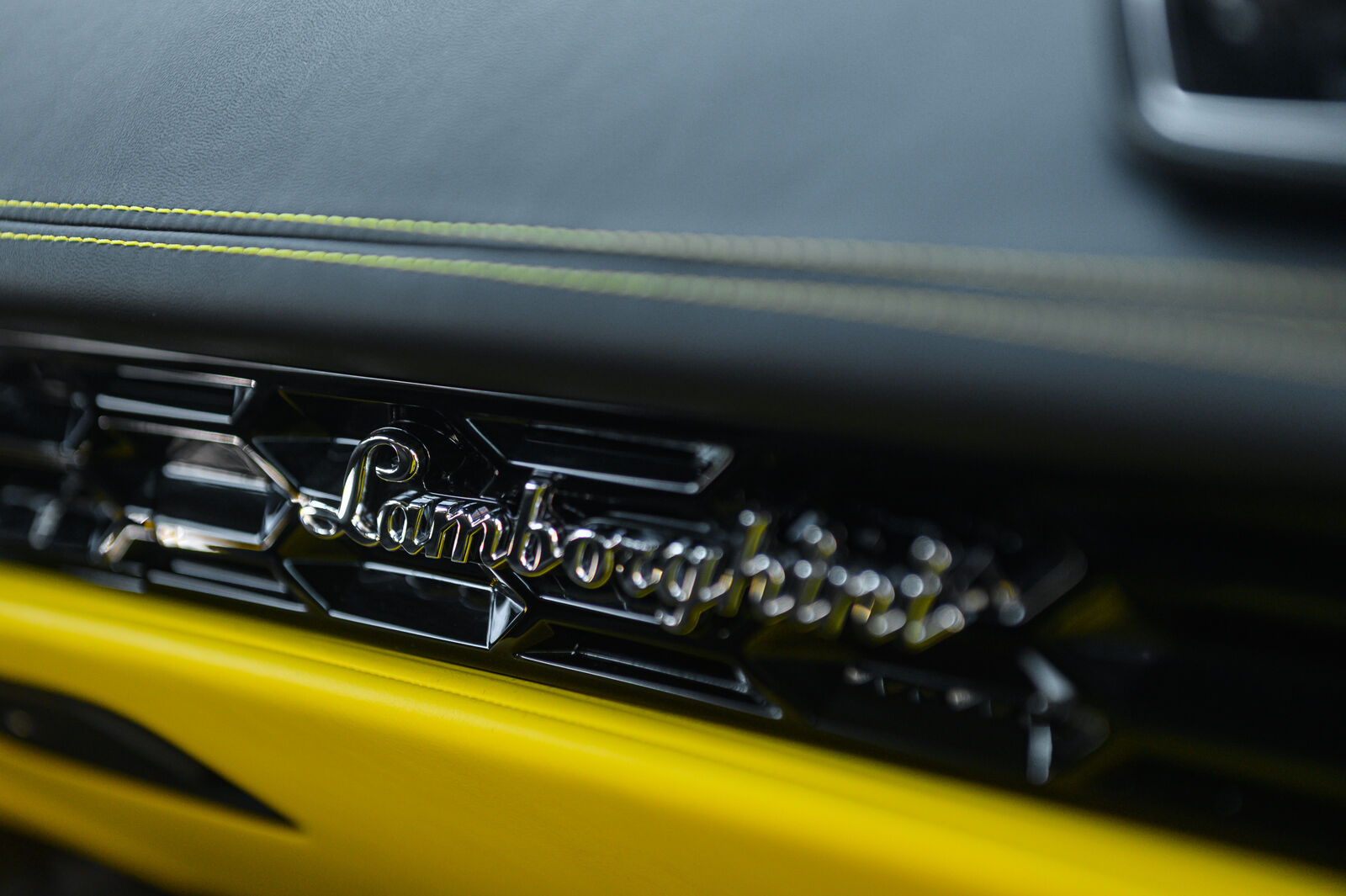 Напис Lamborghini на торпедо з жовтим контрастним швом